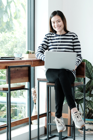 Young asian woman using laptop computer in casual lifestyles, people and technology, lifestylesの写真素材