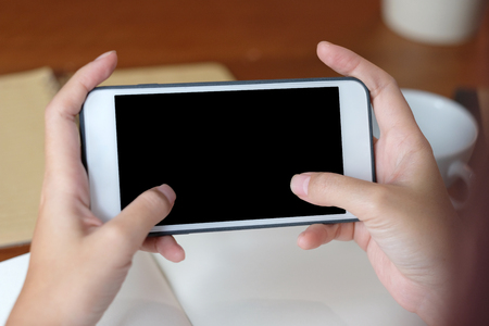 Woman hands using smart phone with blank screen background for mock up, template, technology and lifestyle conceptの写真素材