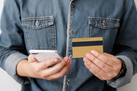 Man hands using smart phone and holding credit card, shopping online concept, mobile banking,...