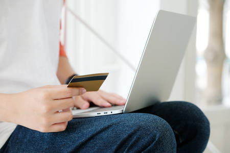 Man holding credit card and using laptop computer to shopping on line, business and technology concept, digital marketing, casual lifestyleの写真素材