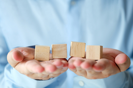 Hand holding four blank wooden cubes, business concept background, mock up, templateの写真素材