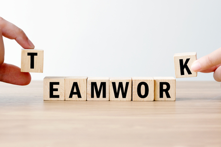 Man and woman hand building teamwork word on wooden cubes, success in business concept backgroundの写真素材