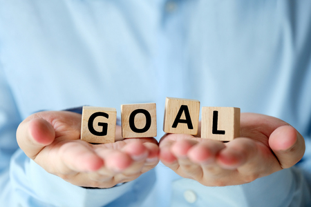 Goal, business word on wooden cubes in man hands, success in business conceptの写真素材