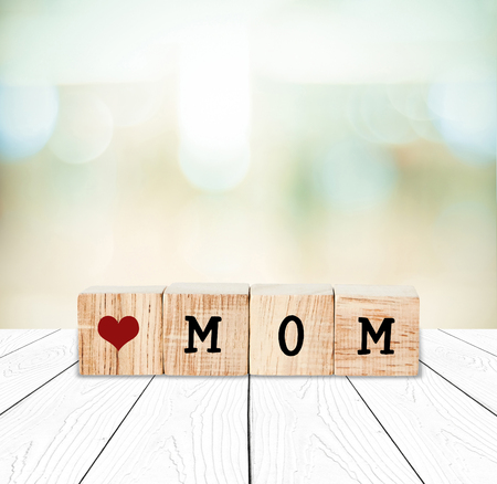 Happy mother's day greeting card, Love mom word on wooden cubes over blur background with copy space for textの写真素材