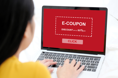 Woman using laptop computer with discount coupon on screen to get the shopping on line promotion, on line shopping ,digital marketing business and technology, lifestyle conceptの写真素材