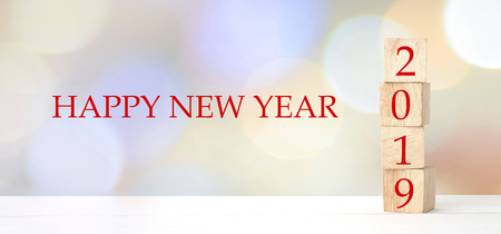 2019 happy new year greeting card, Wooden cubes with 2019 and Happy new year celebration over blur...