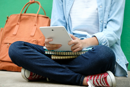 Student girl sitting and using digital tablet, online education, adult learning concept