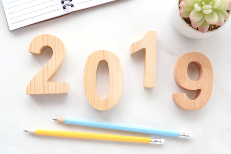 2019 wood letters, notebook paper and pencils on white marble table background, 2019 new year...