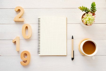 2019 wood letters, blank notebook paper and coffee on white table background, 2019 new year mock up, template with copy space for text, top viewの写真素材
