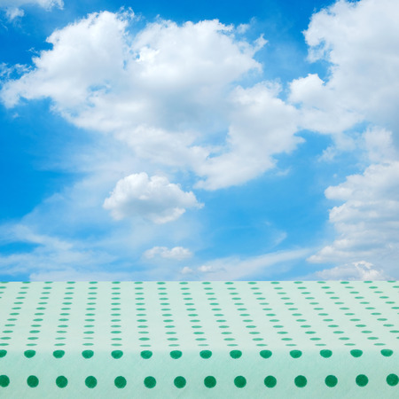 Empty table with green tablecloth over blue sky nature background, product display montageの写真素材