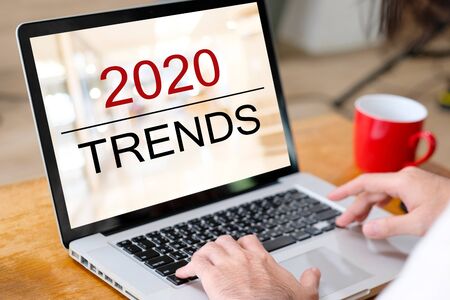 2020 digital trends, Man hand tying laptop computer with 2020 trends on screen background, digital marketing, business and technology conceptの写真素材