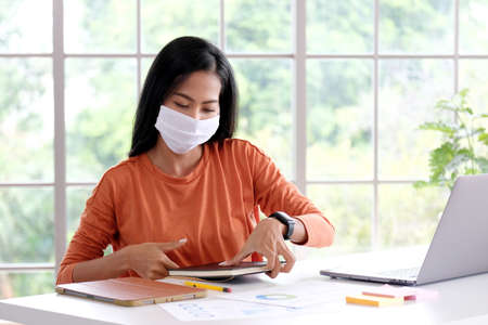 Coronavirus, Asian woman working from home wearing protective mask, Asia girl in quarantine for...