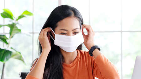 Young asian woman wearing protective mask while working at home, Asia girl in quarantine for...