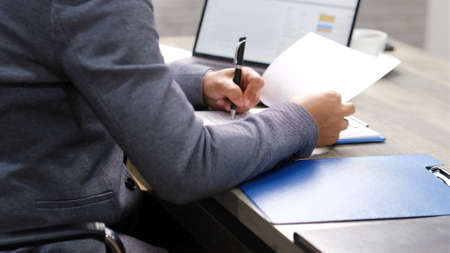 Close up of businessman hand signing contract on application form at office, business collaboration,...