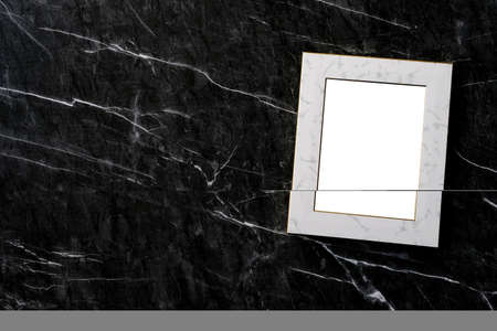 Empty white vintage wooden frame standing over white cement wall and black marble floor with shadow background, copy space for mock up and templateの写真素材