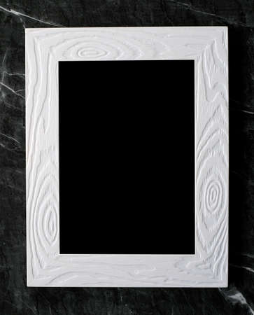 Empty white vintage wooden frame on black marble floor background, copy space for mock up and...