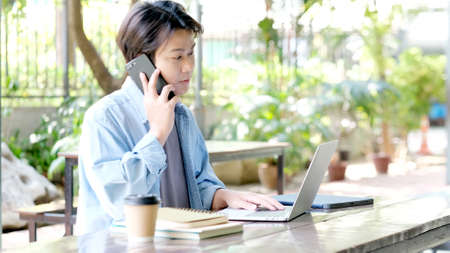 Work from home, Happy young asian man using mobile phone at home office, Asia male smiling while using smartphone, People and technology, e commerce, online business, e learning, education, lifestyle conceptの写真素材