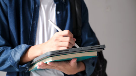Close up of man hand writing on digital tablet while working at home, online study, telecommunicationの写真素材