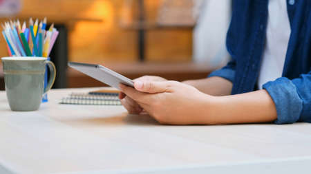 Close up of man hand using digital tablet for working at home, online study, telecommunicationの写真素材
