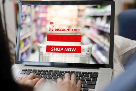 E-coupon, discount coupon web banner over blur grocery background, shopping on line promotion, on line shopping, digital marketing, business and technology conceptの写真素材