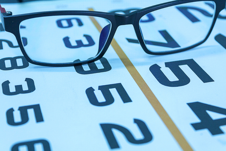 glasses on Snellen eye sight chart test