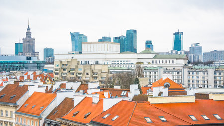 Panoramic view of Warsaw. In the foreground are the roofs of the old city center with tiled roofs. In the background are modern high-rise buildingsのeditorial素材