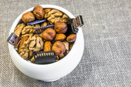 Composition of nuts and memory cards. Symbolizes the useful properties of nuts to improve human...