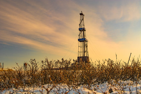 The sparse vegetation of the northern tundra at the beginning of winter in the Arctic. In the background is a drilling rig for oil and gas drilling.のeditorial素材