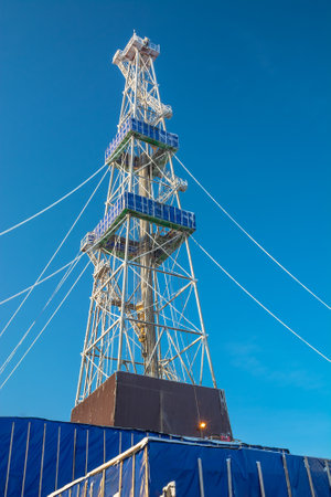 Drilling a well in winter at a northern oil and gas field. The drilling rig is covered in snow.のeditorial素材