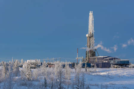 Winter landscape of a taiga forest with a drilling rig at the Northern oil and gas field. Everything...