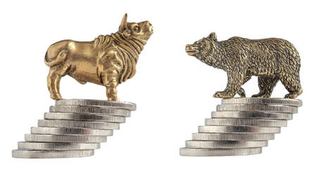 Isolated image of yellow metal bull and bear figurines on the background of metal coins. The concept of exchange symbols of trade, the struggle of buyers and sellers in the market. A series of imagesの写真素材