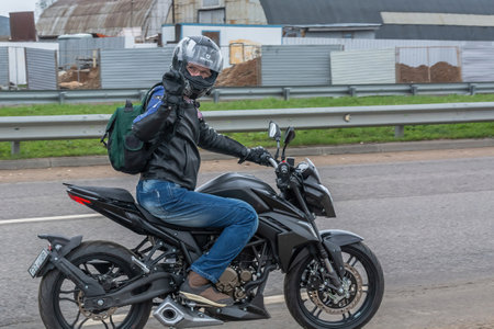 Tver Russia - April 24 2021: Young man in helmet and equipment rides a motorcycle on the road....