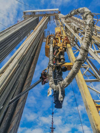 Type derrick inside upwards. Drill pipes are installed in two on the inside. Top power drive for drilling and mud hose for drilling mudの写真素材