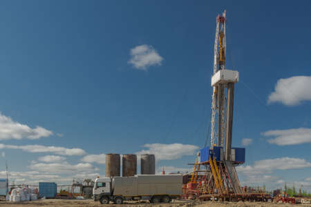 Drilling rig with well cementing equipment in the foreground. Infrastructure, communications and drilling equipment are visible. Cementing unit on a car chassis. Cement storage tanksの写真素材