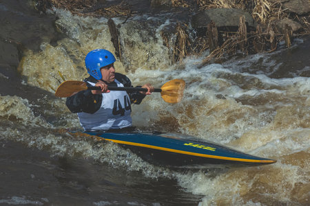 Tver Russia April 9, 2022: A series of images. Athletes in kayaks and kayaks conquer the stormy waters of the river. Dressed in waterproof clothes. They hold an oar in their hands. motion blurのeditorial素材
