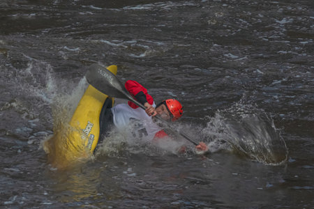 Tver Russia April 9, 2022: A series of images. Athletes in kayaks and kayaks conquer the stormy waters of the river. Dressed in waterproof clothes. They hold an oar in their hands. motion blurのeditorial素材