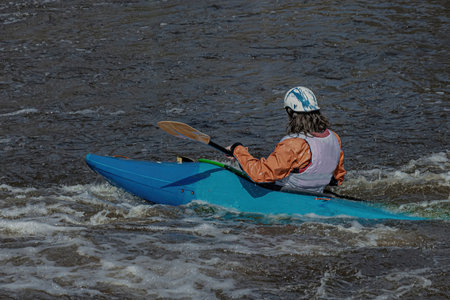 A series of images. Athletes in kayaks and kayaks conquer the stormy waters of the river. Dressed in waterproof clothes and helmets. They hold an oar in their hands. motion blurの写真素材