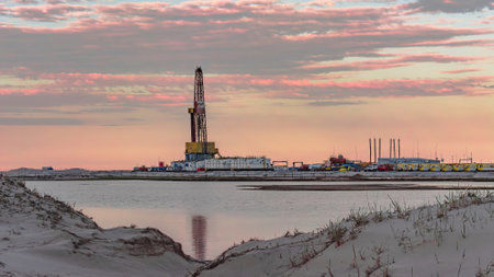 Drilling oil and gas wells in desert terrain. Sand hills, sparse vegetation. Beautiful sky. Infrastructure of the drilling rigの写真素材