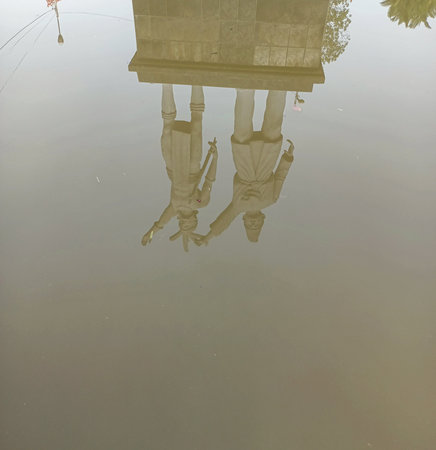 Shadows of Dayak and Malay statues in the waterの写真素材