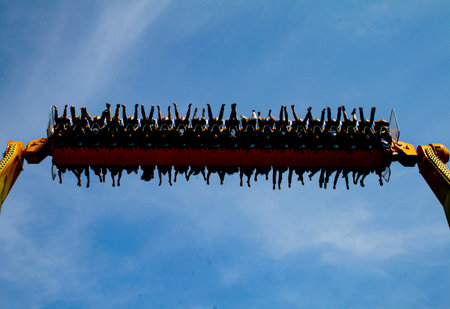 Riders on the TORNADO swing ride, with their arms and legs dangling just above their heads at the thrilling Dunia Fantasi amusement park in Jakarta. Jakarta, Nov 01, 2008.の写真素材