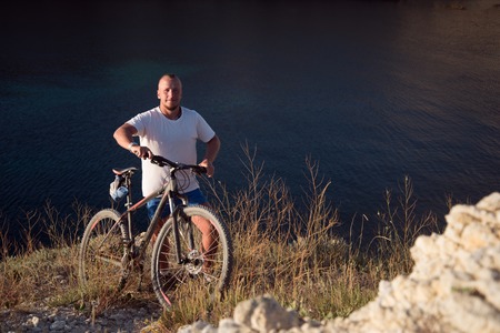 The man with the bike on the coast