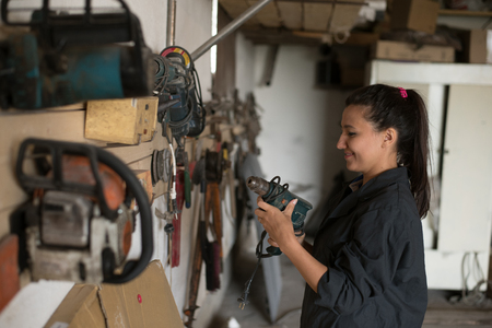 Girl holding a tool nahodyas in the workshop