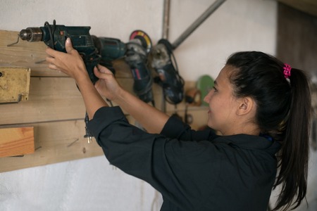 Girl holding a tool nahodyas in the workshopの写真素材