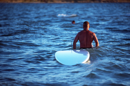 Athletic Male walking on the water with the surfboardの写真素材