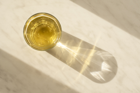 Transparent glass Cup with pear lemonade on a marble surface under the sunの写真素材