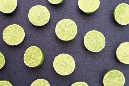 Background of limes split in half on black backgroundの写真素材