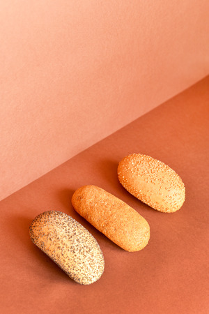 Different breads on a brown surface.Bread with poppy seeds and sesame seeds.の写真素材