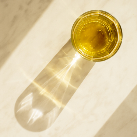 Transparent glass Cup with pear lemonade on a marble surface under the sun. Top viewの写真素材
