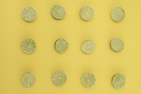 Lime split in half on a yellow background