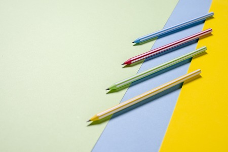 Multi-colored striped beautiful pencils in tri-color background yellow, blue and greenの写真素材